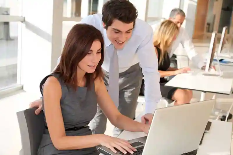 Employees around a computer looking at automatic document retention software