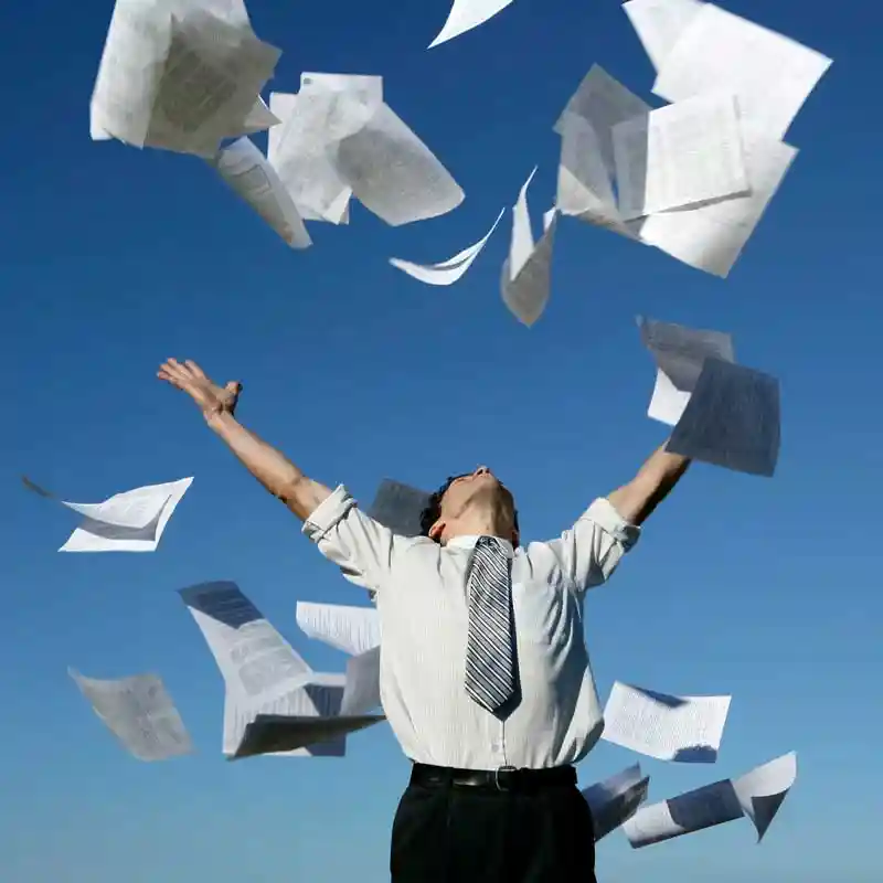 Man throwing papers in the air symbolizing a paperless office