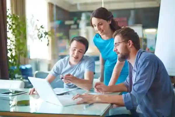 Human Resources employees looking at workflow software on a laptop